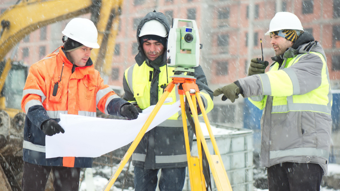 Group of construction workers working outside in the snow